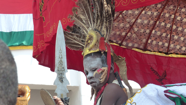 A child of the royal court, carried into the parade and painted in white.  